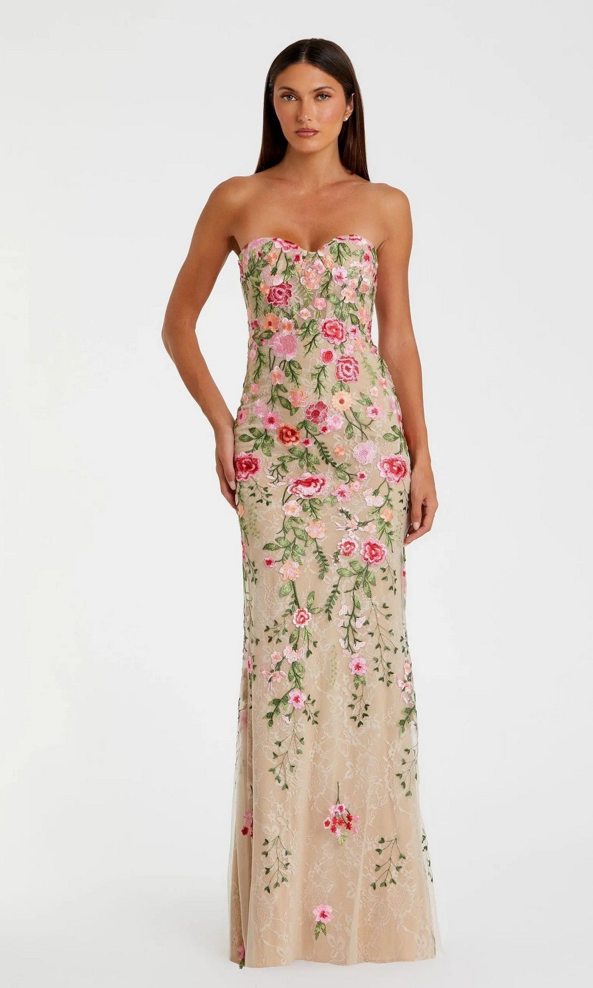 A woman models the Mac Duggal 68894 Long Formal Dress in Nude Multi—a strapless, floor-length gown embellished with pink and green floral embroidery—standing against a plain white background.